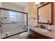 Well-lit bathroom featuring tub-shower combination with glass doors and a vanity with granite countertop at 2723 59Th St, Sarasota, FL 34243