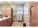 Stylish bathroom featuring glass block shower, single sink vanity and decorative window at 2723 59Th St, Sarasota, FL 34243