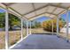 View from the open carport structure looking out to the trees and foliage surrounding the property at 2723 59Th St, Sarasota, FL 34243
