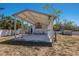 Angled view of the open carport structure with a concrete pad and white metal roof and columns at 2723 59Th St, Sarasota, FL 34243