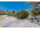 Serene view of single-story home partially hidden by trees and shrubbery at 2723 59Th St, Sarasota, FL 34243