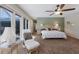 Relaxing main bedroom featuring a ceiling fan, wicker headboard, and a comfy chair with patio access at 2723 59Th St, Sarasota, FL 34243
