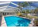 Bright blue pool with screened enclosure, surrounded by lush landscaping, creates a private backyard retreat at 2723 59Th St, Sarasota, FL 34243