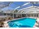 Large screened-in pool surrounded by seating and lush greenery, perfect for entertaining and relaxation at 2723 59Th St, Sarasota, FL 34243