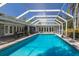 Clear, blue pool with screen enclosure provides a stunning focal point in the expansive backyard oasis at 2723 59Th St, Sarasota, FL 34243
