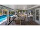 Screened patio with dining table overlooks a bright blue swimming pool and manicured backyard at 2723 59Th St, Sarasota, FL 34243