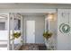 Charming covered porch features hanging plants, brick flooring and decorative wall art at 2723 59Th St, Sarasota, FL 34243