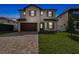 Two-story home with dark wood garage and paver driveway at 3113 W Nassau St, Tampa, FL 33607
