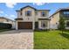 Stunning two-story home featuring a brick driveway, attached garage, and lush green lawn at 3113 W Nassau St, Tampa, FL 33607