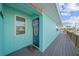 Charming home exterior with a teal-colored front door, matching siding, and a welcoming wreath at 3416 Crape Myrtle Dr, Hernando Beach, FL 34607