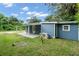 The backyard of the blue home featuring a covered patio and bright green grass at 3608 Water St, Ellenton, FL 34222