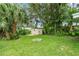 Lush backyard features a fire pit, palm trees, and a storage shed at 3608 Water St, Ellenton, FL 34222