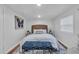 Comfortable bedroom with white bedding, wicker headboard, and a blue geometric-patterned bench at 3608 Water St, Ellenton, FL 34222