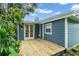Charming blue home with a wooden deck and lush landscaping at 3608 Water St, Ellenton, FL 34222