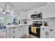 Bright kitchen with white cabinets, modern appliances, and a view of the living area at 3608 Water St, Ellenton, FL 34222