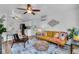 Bright living room with a yellow sofa, ceiling fan, and modern decor at 3608 Water St, Ellenton, FL 34222
