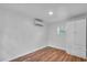 Clean, white room with wood flooring, split air conditioner, and a wall closet with drawers at 3608 Water St, Ellenton, FL 34222