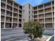 Exterior of condo building showcases well-maintained landscaping with blooming flowers and a patriotic American flag at 3744 Lake Bayshore Dr # K-503, Bradenton, FL 34205
