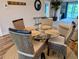 A dining area featuring a round glass table with four wicker chairs, complemented by hardwood floors and neutral walls at 3744 Lake Bayshore Dr # K-503, Bradenton, FL 34205