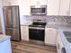 Modern kitchen with stainless steel appliances, including a refrigerator, microwave, oven, and sleek granite countertops at 3744 Lake Bayshore Dr # K-503, Bradenton, FL 34205