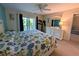 A bright main bedroom with a fan, balcony access, and a dresser with a large mirror at 3744 Lake Bayshore Dr # K-503, Bradenton, FL 34205