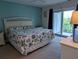 A spacious main bedroom with blue accent wall, balcony access and neutral carpet at 3744 Lake Bayshore Dr # K-503, Bradenton, FL 34205