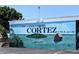 Welcome to Historic Cortez Village mural with coastal scene, cottage on water, and boat at 3744 Lake Bayshore Dr # K-503, Bradenton, FL 34205