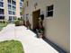 Well-maintained walkway to pool entrance, decorated with potted plants and building number displayed at 3744 Lake Bayshore Dr # K-503, Bradenton, FL 34205