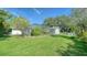 Expansive backyard with lush green grass and a screened-in pool at 3761 Countryside Rd, Sarasota, FL 34233