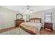 Cozy bedroom with a ceiling fan, dresser with mirror, and two bedside tables at 3761 Countryside Rd, Sarasota, FL 34233