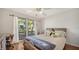 Bedroom with large window providing an outdoor view, complemented by a ceiling fan and wooden floors at 3761 Countryside Rd, Sarasota, FL 34233