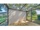 Enclosed lanai featuring wood flooring, a stucco privacy wall, and a view of a lush green yard at 3761 Countryside Rd, Sarasota, FL 34233