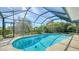 Screened in backyard pool surrounded by tropical foliage at 3761 Countryside Rd, Sarasota, FL 34233