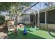 Backyard with a playset, swing set, trampoline, and artificial turf for Gathering fun at 3941 Pin Oaks St, Sarasota, FL 34232