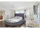 Well-lit bedroom featuring a unique round bed, hardwood floors, and a cozy crib nearby at 3941 Pin Oaks St, Sarasota, FL 34232