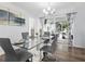 Chic dining area featuring a glass table, modern chairs and a view of the outdoor patio through sliding doors at 3941 Pin Oaks St, Sarasota, FL 34232
