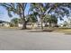 Well-maintained single-story home with mature trees, driveway, and manicured lawn at 3941 Pin Oaks St, Sarasota, FL 34232