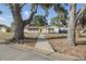 Inviting single-story home featuring mature trees, decorative stone accents and a quaint front entrance at 3941 Pin Oaks St, Sarasota, FL 34232