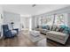 Bright living room with hardwood floors, plush seating, and plenty of natural light from a large window at 3941 Pin Oaks St, Sarasota, FL 34232