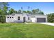 Inviting single-story home with a well-maintained lawn, stone veneer accents, and attached garage at 4008 Antelope Ter, North Port, FL 34286