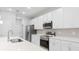 Modern kitchen with stainless steel appliances, white cabinets, and a stylish backsplash at 4008 Antelope Ter, North Port, FL 34286
