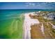 Picturesque aerial view of a sandy beach with turquoise water and buildings nearby at 4307 Camino Real, Sarasota, FL 34231