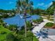 An elevated view showcasing a meticulously landscaped home with a striking blue roof and circular driveway at 4307 Camino Real, Sarasota, FL 34231