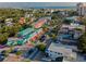 Aerial view of a charming town with colorful buildings, tree-lined streets, and a glimpse of the ocean in the distance at 4307 Camino Real, Sarasota, FL 34231