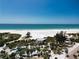 Scenic aerial view of a pristine beach with clear turquoise waters and lush greenery at 4307 Camino Real, Sarasota, FL 34231