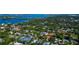 Aerial view of the property and the surrounding wooded neighborhood close to the water at 4307 Camino Real, Sarasota, FL 34231