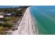 Sweeping aerial view of a pristine white sand beach along a tropical shoreline with crystal-clear turquoise water at 4307 Camino Real, Sarasota, FL 34231