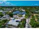 Aerial view of blue-roofed home amidst lush greenery, showcasing its unique architecture and landscaping at 4307 Camino Real, Sarasota, FL 34231