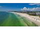 Beautiful aerial view of white sand beach, ocean, and blue sky in a desirable coastal community at 4307 Camino Real, Sarasota, FL 34231