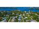 Aerial view of blue-roofed home in neighborhood, highlighting its ideal location in a waterfront community at 4307 Camino Real, Sarasota, FL 34231